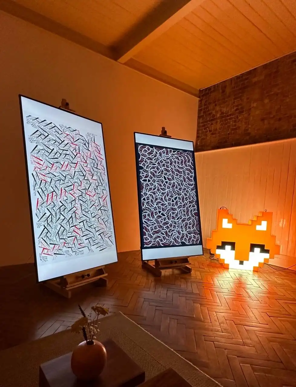 Two INTRICADA pieces on easels beside a pixel-art fox lamp, Bright Moments London.
