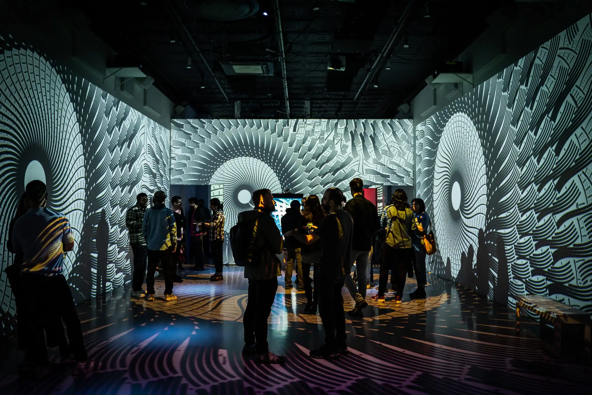 Visitors in a room of spiral projections, Lume Studios, New York.