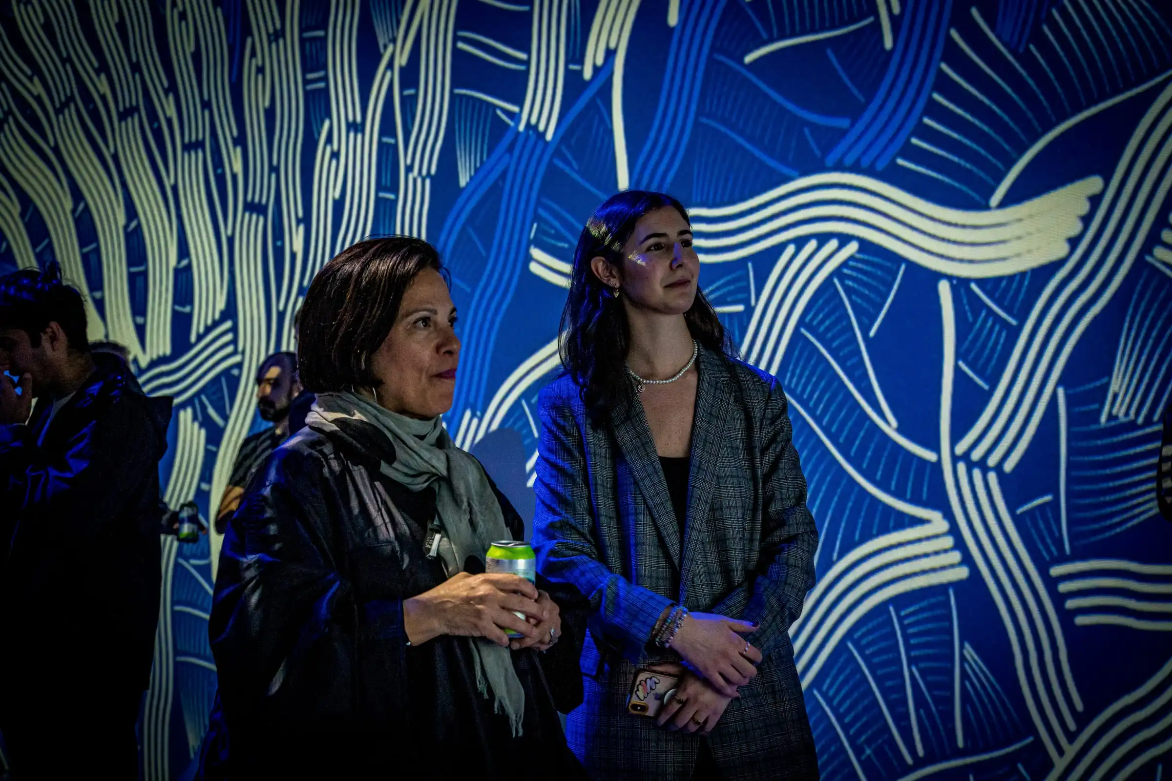 Visitors in front of blue INTRICADA projections, Lume Studios, New York.