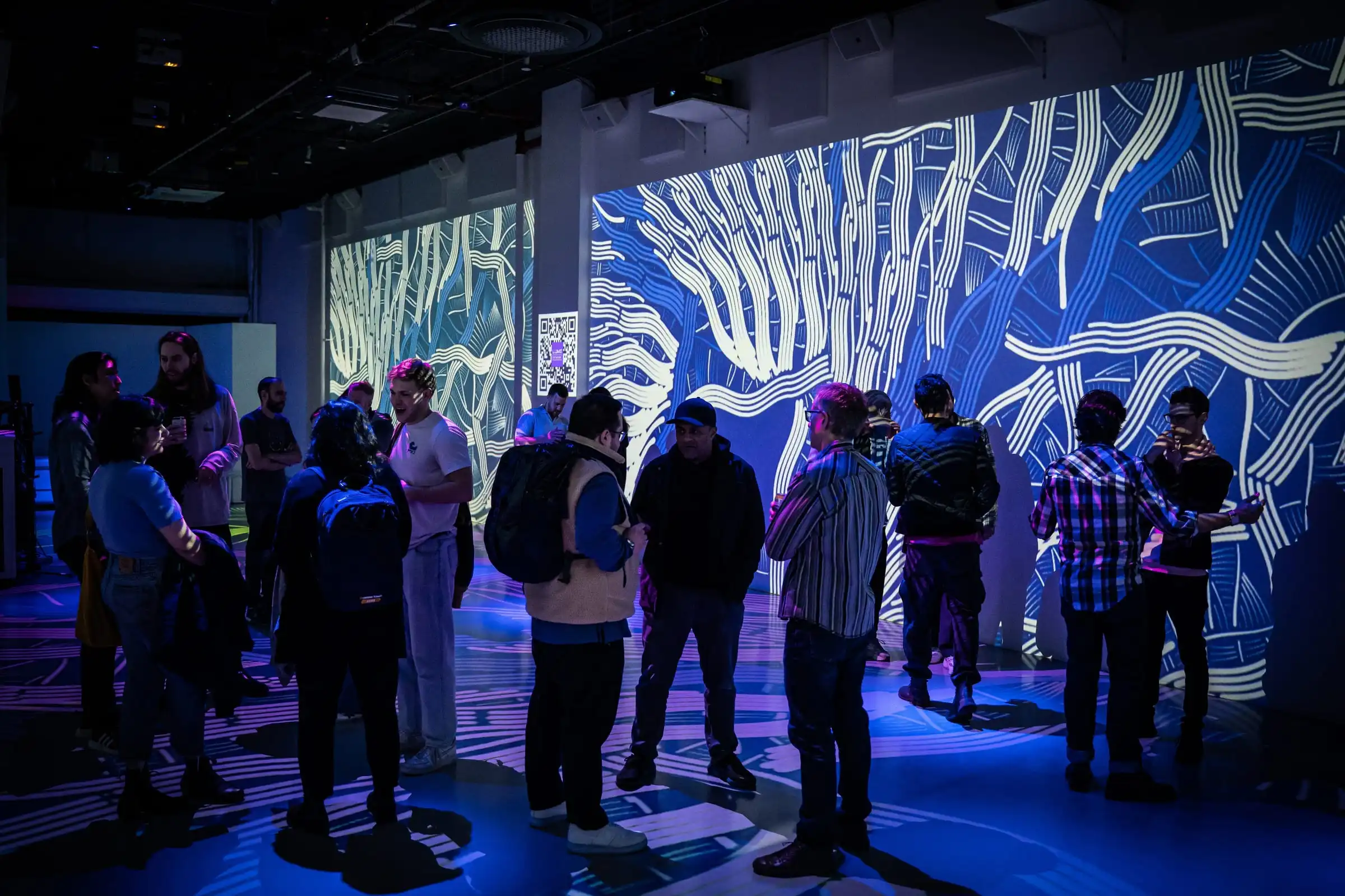 Visitors in a room covered with INTRICADA projections, Lume Studios, New York.