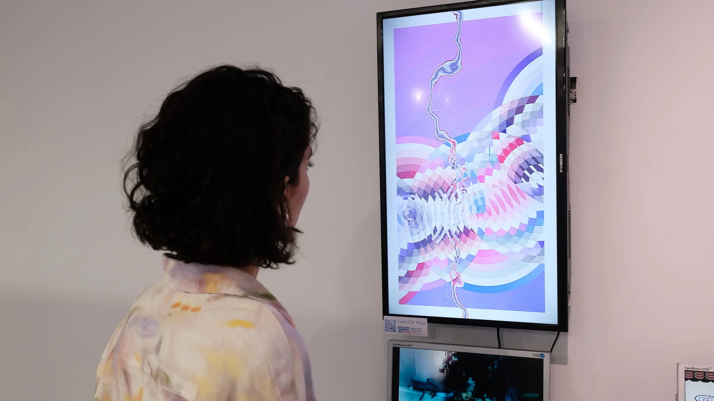 A visitor faces a purple edition of Résilience on a vertical screen, Iran Computer Museum, Tehran.