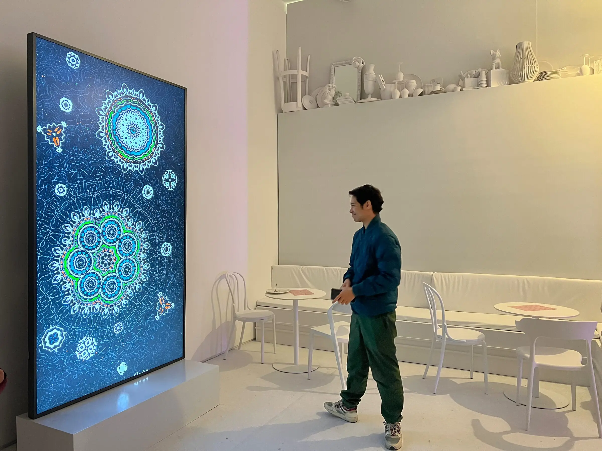 The Destination on a large vertical screen in a white room, Bright Moments Paris.